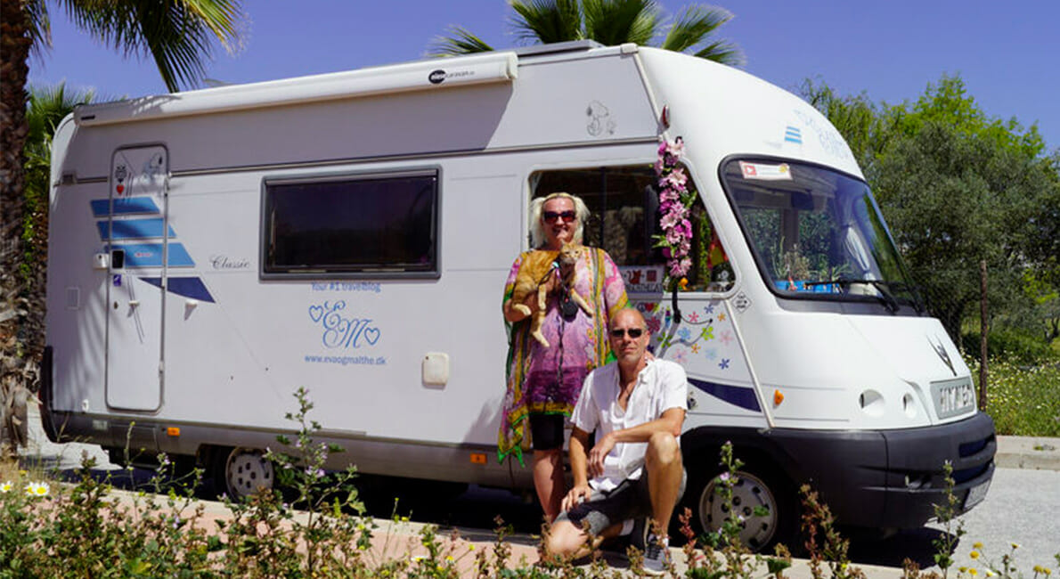 mand og kvinde poserer foran en autocamper