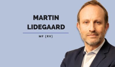En person i et marineblåt jakkesæt med en lyseblå skjorte mod en lyseblå baggrund. Teksten lyder "Martin Lidegaard MF (RV)" ved siden af personen.